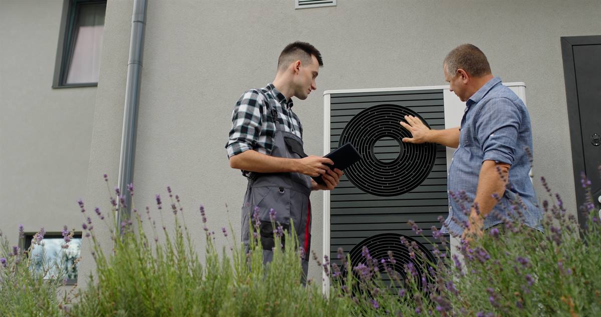 GreenShield technician reviewing heat pump options with a Nassau County homeowner