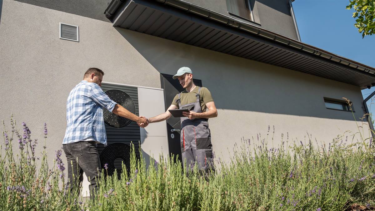 Homeowner discussing heat pump service options with a GreenShield installer